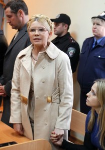 Julija Timosenko volt ukrán miniszterelnök a lánya kezét fogja a vádlottak padján egy kijevi bíróságon 2011. október 11-én