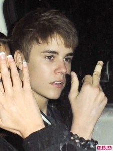 Justin Bieber amerikai énekes, mellette barátnőjének, Selena Gomez amerikai énekes-színésznőnek a keze látható Justin Bieber amerikai énekes, mellette barátnőjének, Selena Gomez amerikai énekes-színésznőnek a keze látható