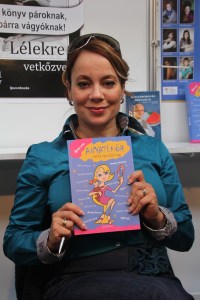 Csisztu Zsuzsa egykori sportoló, műsorvezető kezében az Anyatükör című kötettel a XIX. Budapesti Nemzetközi Könyvfesztiválon a Millenárison 2012. április 20-án