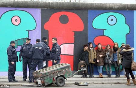  A berlini fal egyik meghagyott, Keleti Oldali Galéria (East Side Gallery) nevű szakaszán rendőrök és tüntetők, akik a fal ezen szakaszának lebontása ellen demonstrálnak 2013. március 2-á