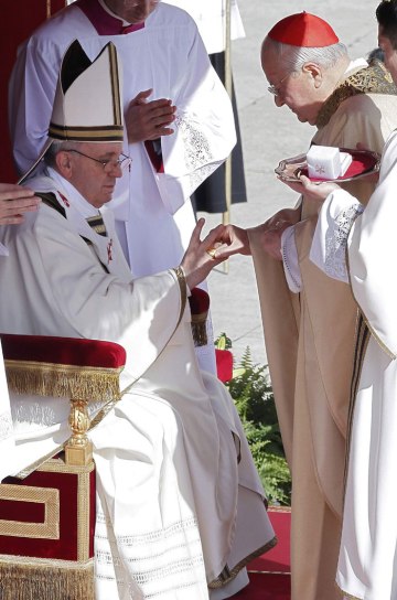 Az olasz Angelo Sodano bíboros, a bíborosi kollégium dékánja átnyújtja a halászgyűrűt Ferenc pápának beiktatási miséjén a vatikáni Szent Péter téren 2013. március 19-én
