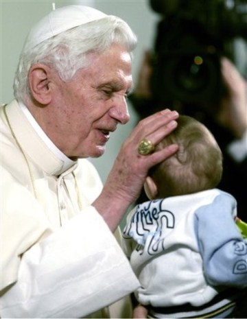 XVI. Benedek pápa egy kisgyermeket áld meg