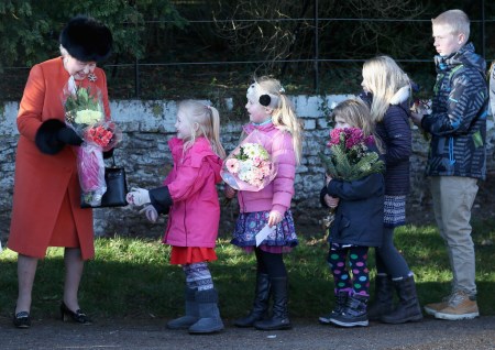 II. Erzsébet brit királynő virágot vesz át a Szent Mária Magdolna templomnál az angliai Sandringhamban 2013. december 25-én